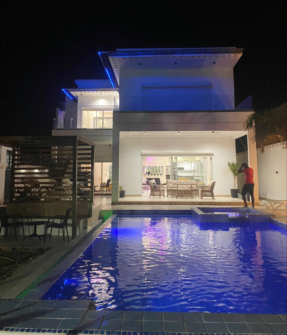 Extérieur nocturne de la villa avec piscine éclairée et terrasse ouverte