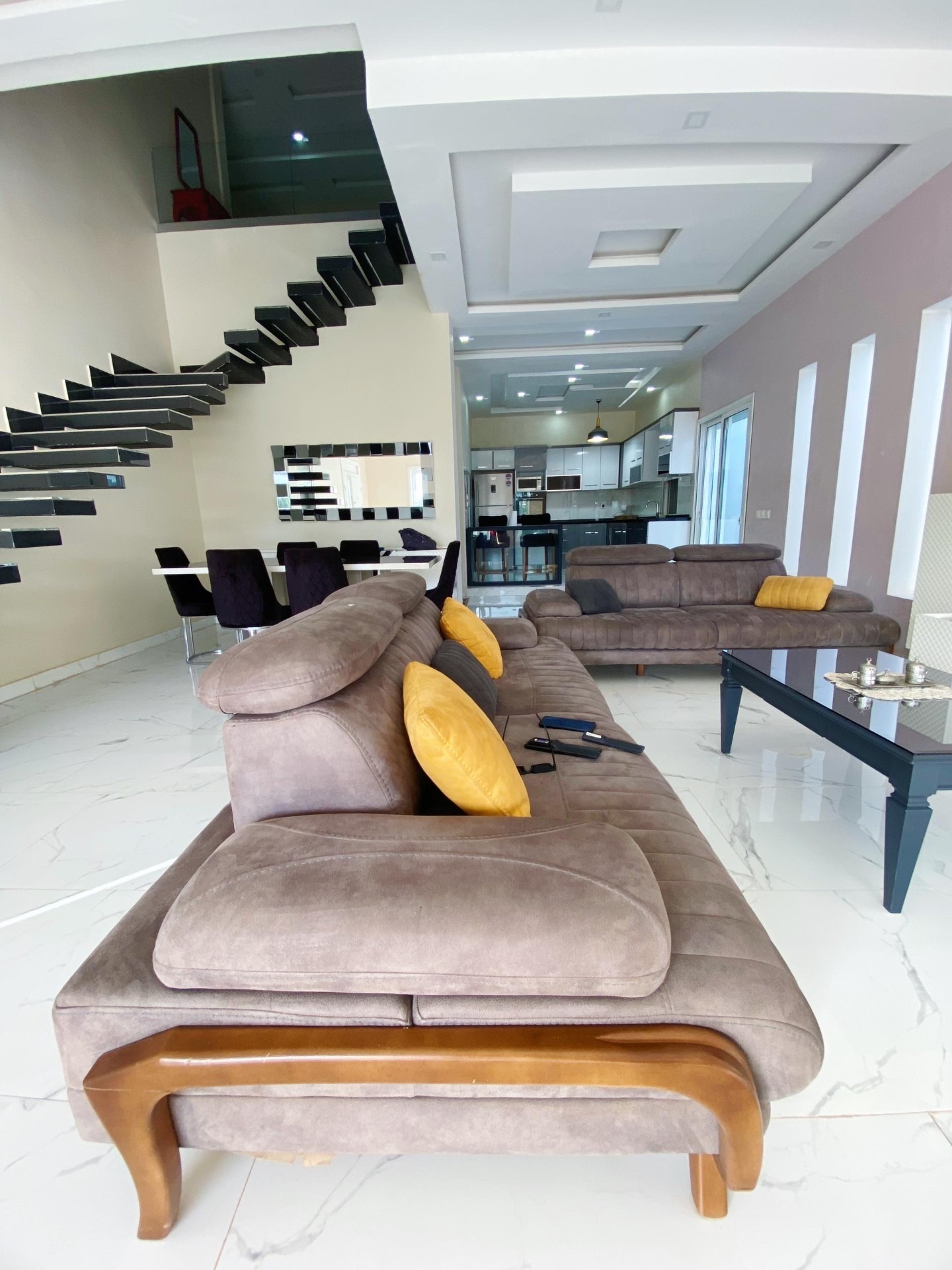 Salon spacieux avec escalier suspendu et salle à manger